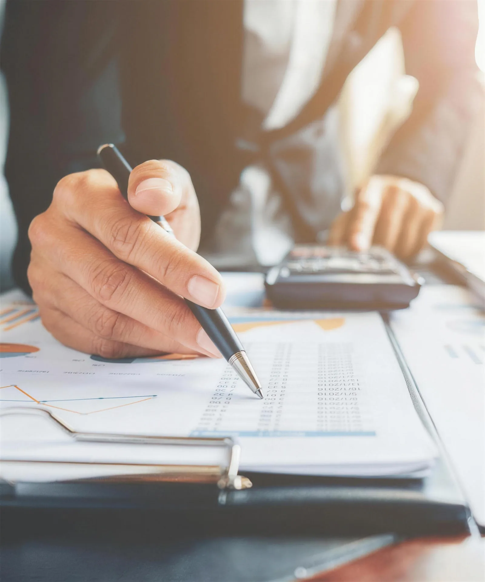 A specialist working through a credit report with a pen and calculator