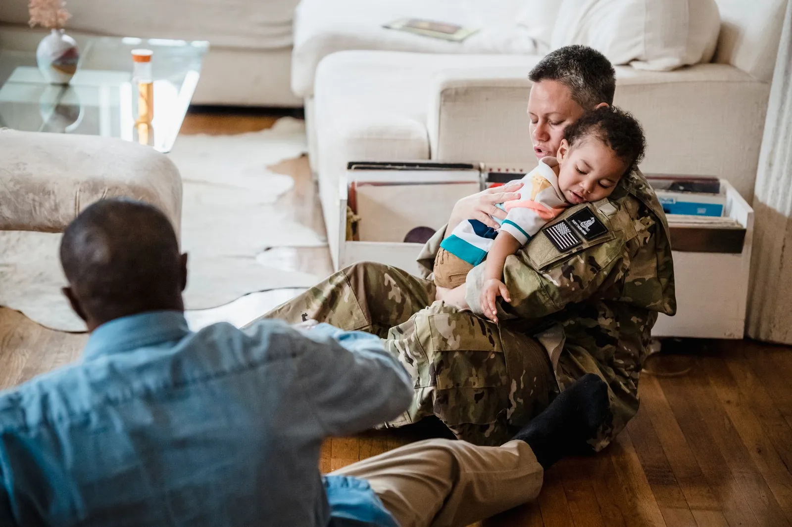 A military parent in uniform embracing their child at a family reunion